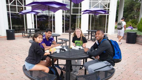 Students at table under awning